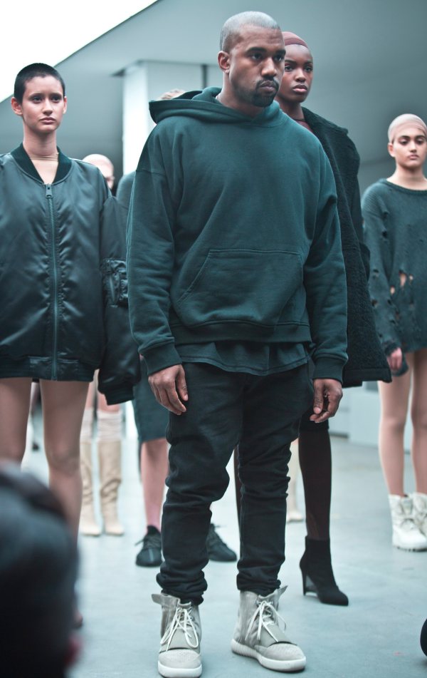 Kanye West appears with models during the showing of his Yeezy Boost shoe line for Adidas on Thursday, Feb. 12, 2015, during Fashion Week in New York. (AP Photo/Bebeto Matthews)